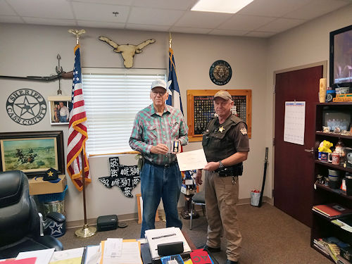 Chapter President Clarence V. Burns presents Officer Eric White of the Cass County Sheriff’s Department with the Law Enforcement Medal and Certificate.