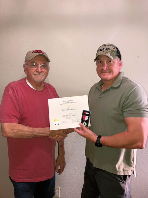 Compatriot Rick Blackwood presents the Life Saving Medal and Certificate to Police Officer Jason Blackwook who gave CPR to a gentleman until EMTs arrived.